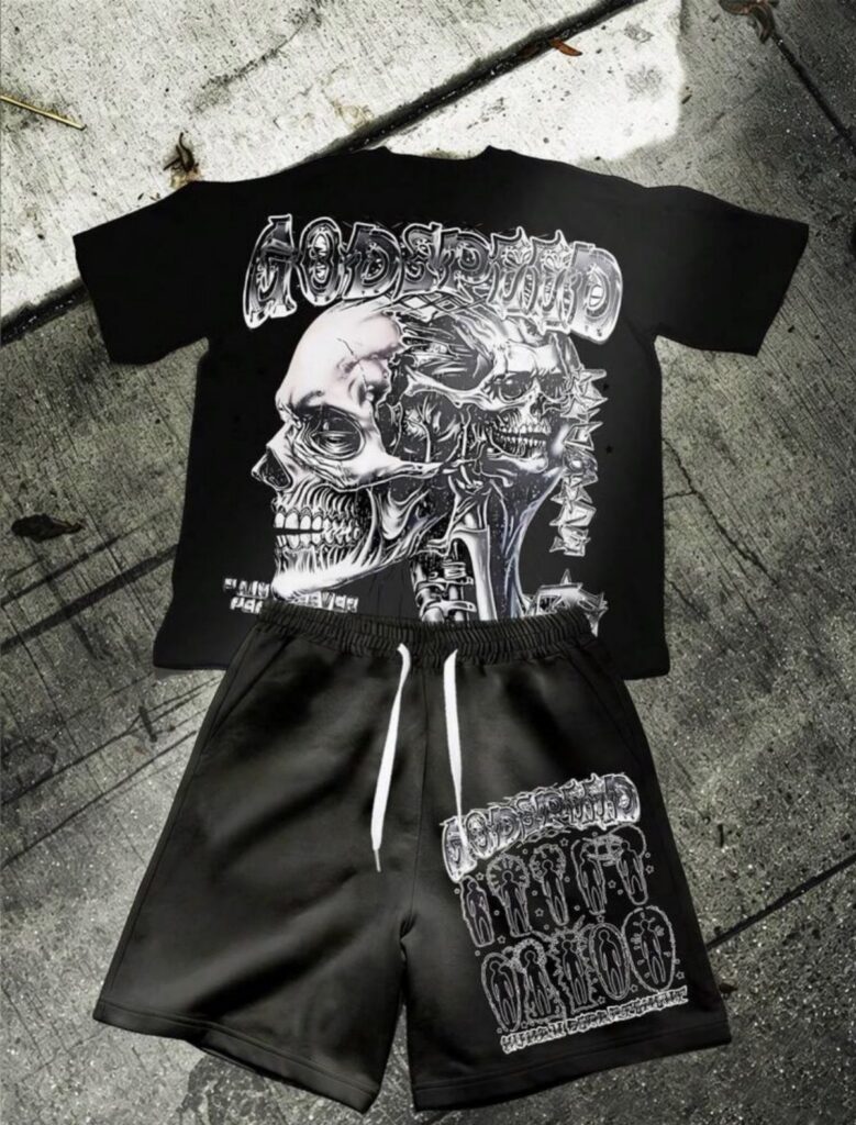 Black graphic t-shirt with skull print and matching black shorts laid on concrete.