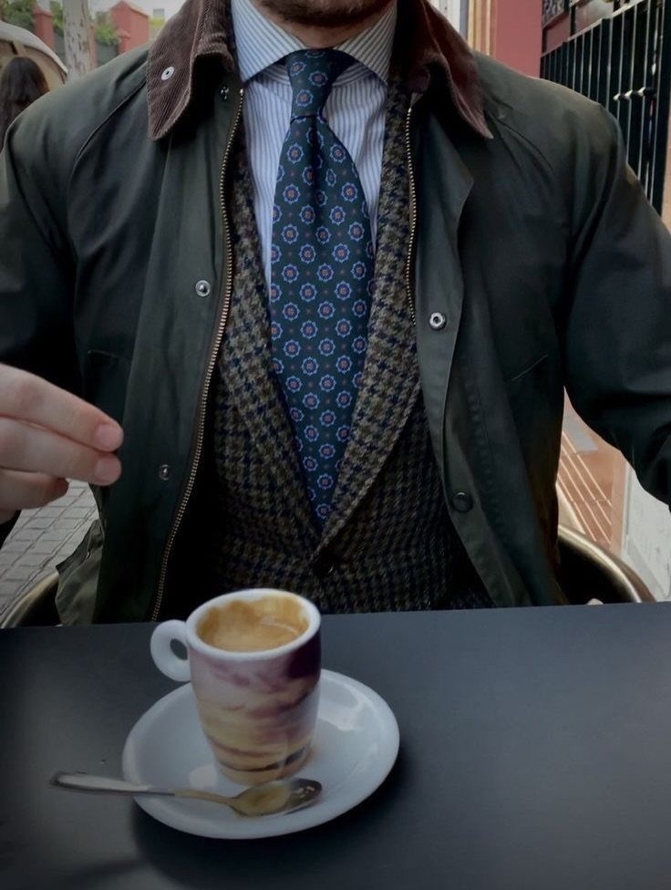 Man dressed in British country style clothing with a green waxed jacket and tweed waistcoat.