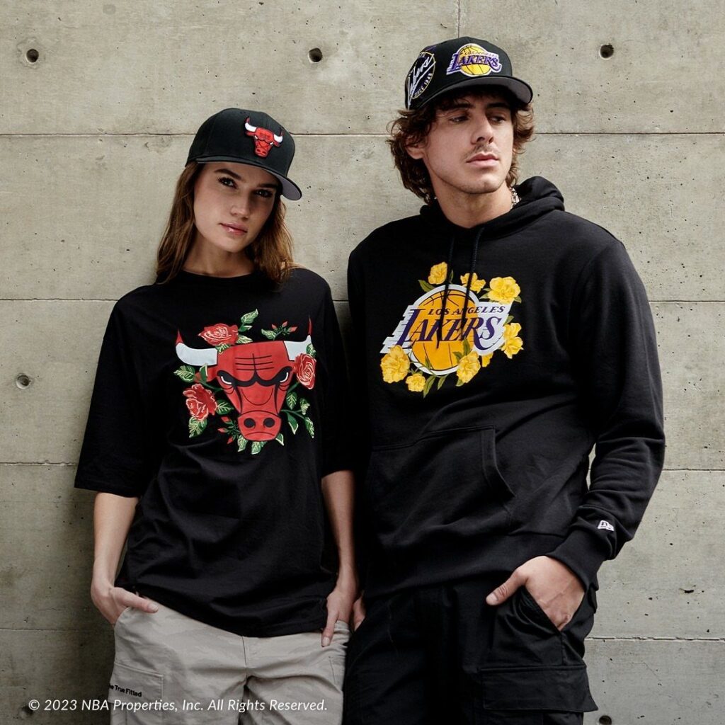 A man and woman wearing black Los Angeles Lakers and Chicago Bulls graphic streetwear apparel.